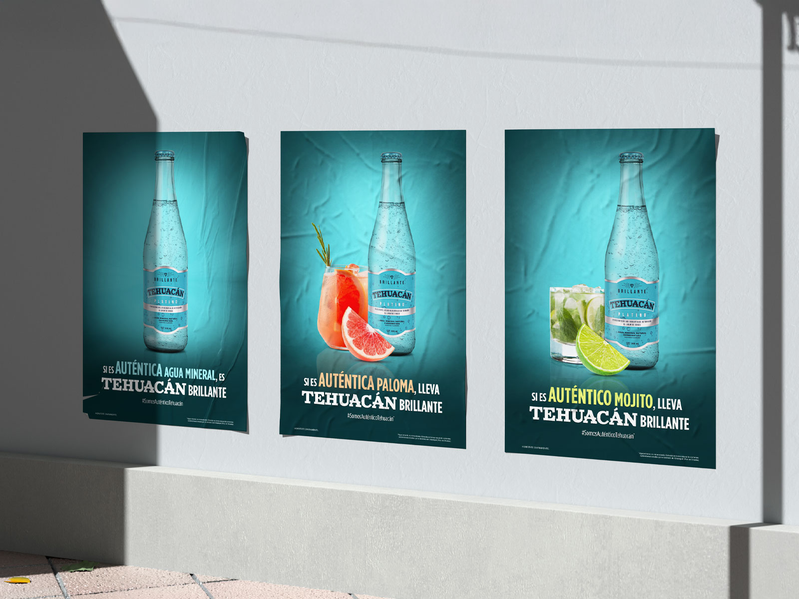 Pared gris muy clara con tres cartelones azul turquesa de Tehuacán Brillante, composición limpia y moderna.