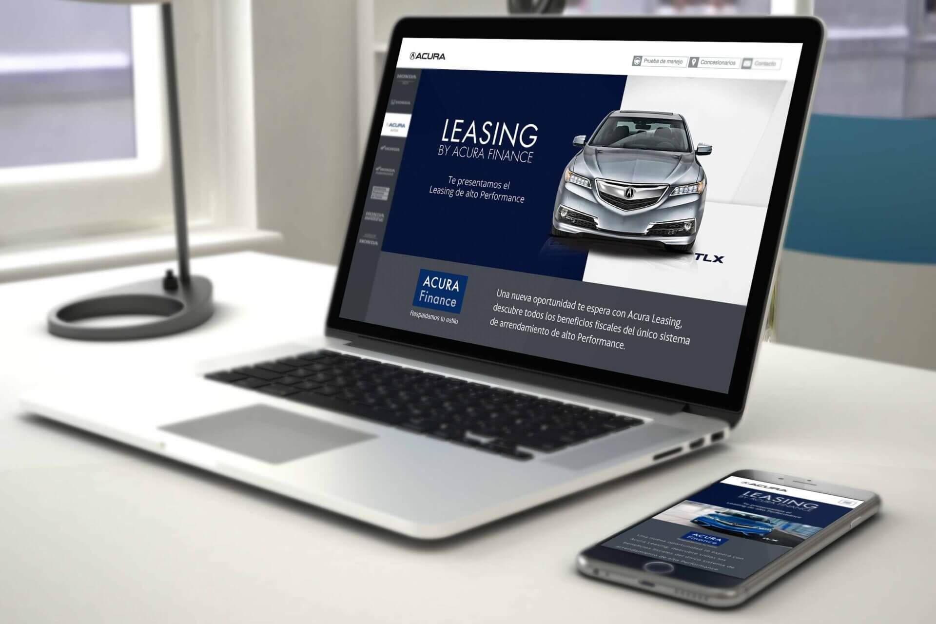 Escritorio Blanco con laptop y celulares plateados mostrando la campaña Leasing Acura en sus pantallas.