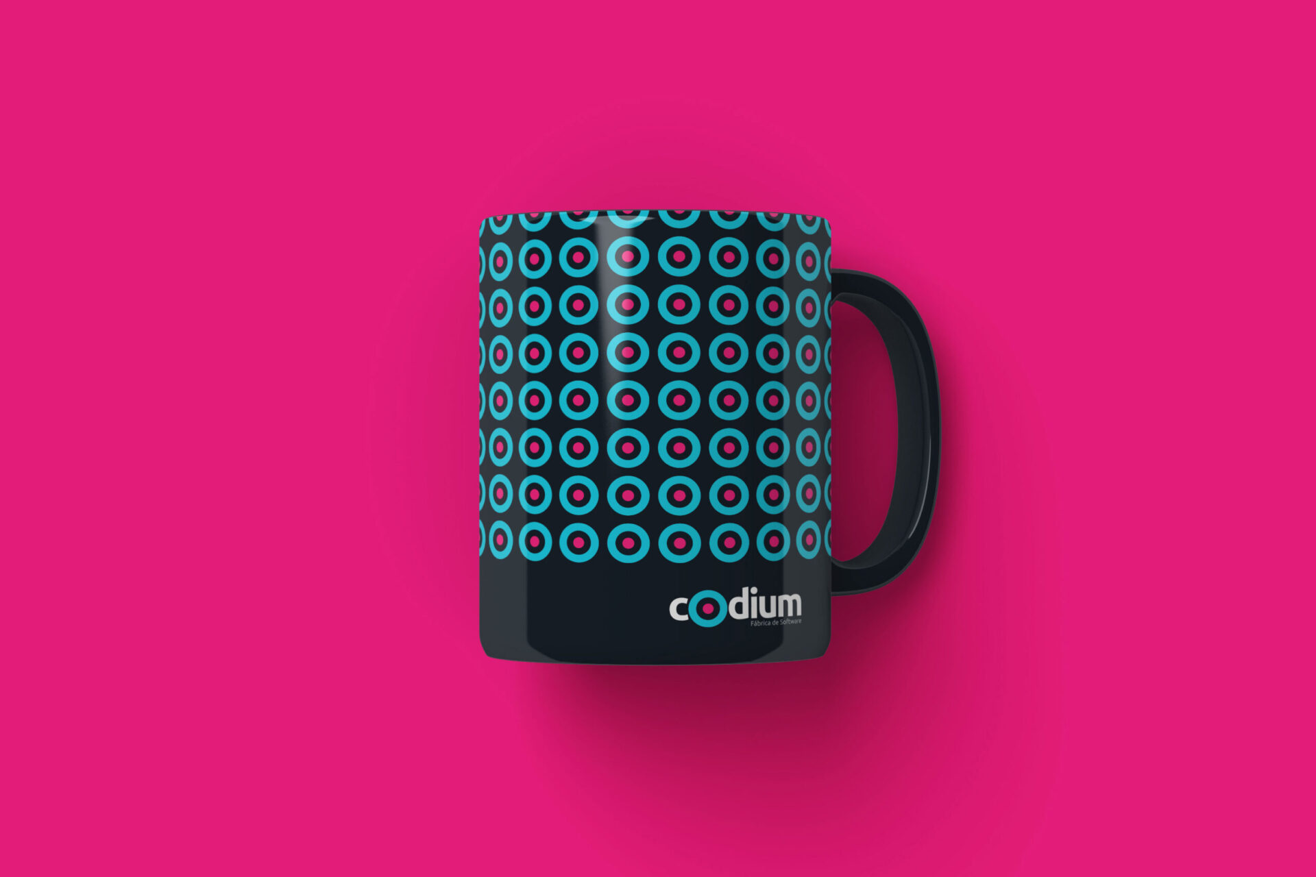 Branding para CODIUM por Carbono Agencia, aplicado en taza negra sobre fondo rosa